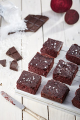 Beetroot brownie with salt on white wooden board