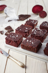 Beetroot brownie on a white wooden background from a side