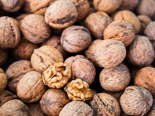 Walnut kernels on natural walnut pattern background, Raw bio walnuts texture, top view
