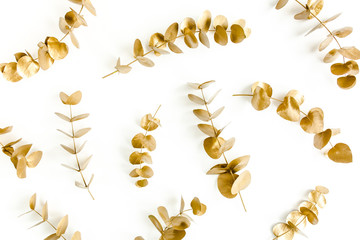 Pattern made of gold branches, eucalyptus leaves on a white background. flat layout, top view