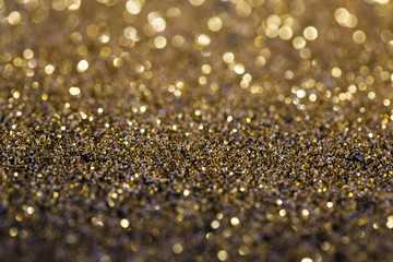 twinkling golden glitter falling on a flat surface lit by a bright spotlight (3d illustration)