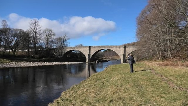 Potarch Bridge lady takes picture in bright spring sunshine
