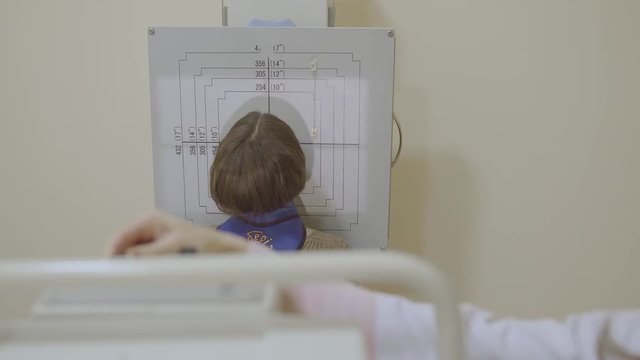 Kid stand near table with numbers in clinic