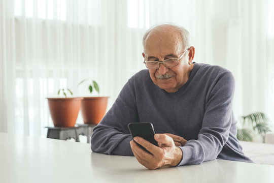 Retired Man Using Computer Technologies At Home.