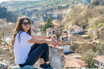 Fototapeta na wymiar Beautiful Young Woman Sitting Above the City of Melnik in Bulgaria . Traveling Concept 