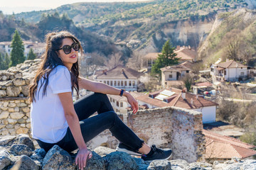 Fototapeta na wymiar Beautiful Young Woman Sitting Above the City of Melnik in Bulgaria . Traveling Concept 
