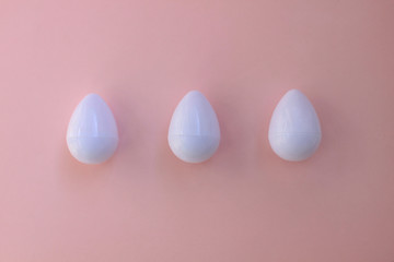 White eggs on the background in pink pastel color.