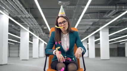 One sad woman throws colorful confetti, sitting in a chair.