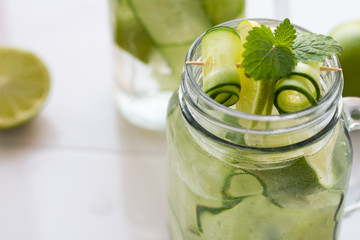 water with mint, lime and cucumber close up and space for text.