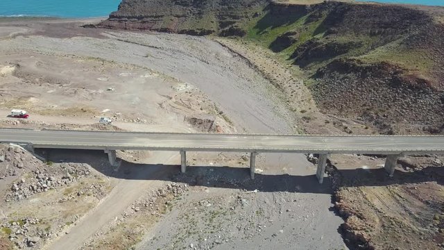 RV trucks travel down dirt detour road under bridge, road unsafe from Hurricane Rosa. Aerial view
