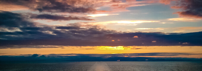 Panorama of midnight sun and clouds in the Norwegian Sea