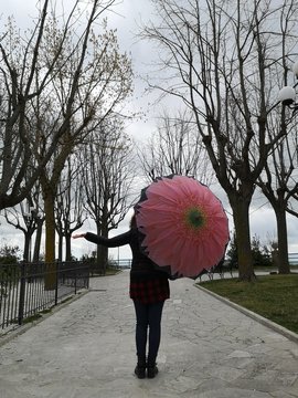 girl walks under umbrella in the park
