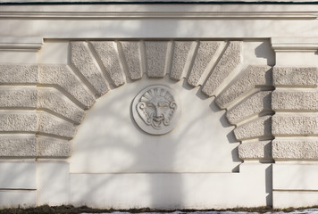 A sculpted face is a decoration ornament of an old wall