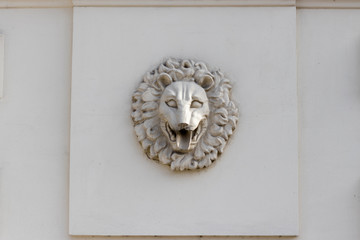 A sculpted lion's head is a decoration ornament of an old wall