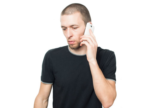 a man in a black shirt talking on the phone on a white background