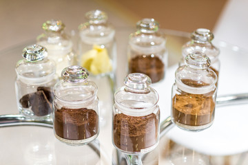 Regular and alkalised cocoa powder on with dar chocolate, in glass jars with lids.