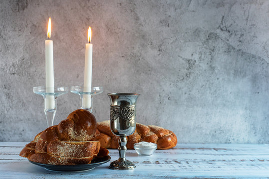 Shabbat Shalom - challah bread, shabbat wine and candles on wooden table