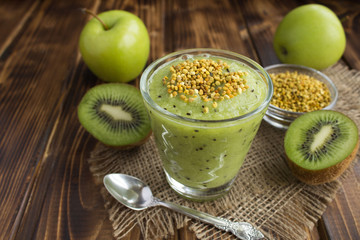 Smoothies  with kiwi, green apples  and  bee pollen on the rustic wooden background
