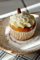 Homemade bakery style vanilla delicious sponge cake with white butter cream cream frosting and almond on top on plate. Candy bar for celebrating partys and birthdays