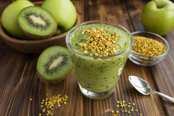 Smoothies with kiwi, green apples  and  bee pollen on the brown wooden background