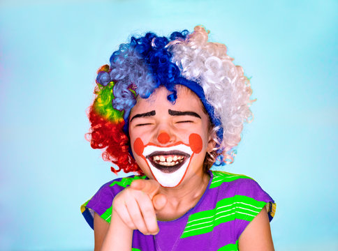 Handsome little boy Laughs and Points Finger. little cute boy with facepaint like clown, pantomimic expression. emotions. April Fool's Day, April 1
