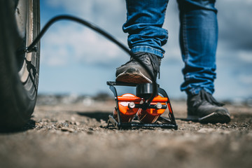 man shakes the wheel with a foot pump large