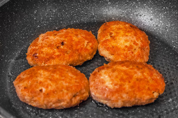 salmon cutlets fried in a pan