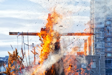 Burning wooden cross. City. National Slavic and pagan customs
