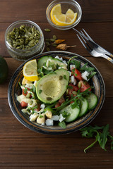 Healthy salad of fresh vegetables - tomatoes, avocado, arugula, egg, spinach. Flat lay. Top view.