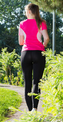 Female 20-30 years old is jogging back in pink T-shirt