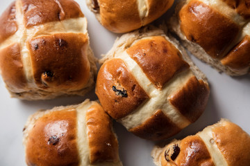Traditional hot cross buns with raisins on a marble surface