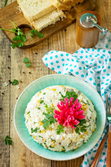 Festive snack on Easter table. Salad with Rice, Onion, Egg, Corn and Mushrooms on table.