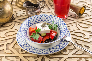 tomato salad with feta cheese and herbs on oriental table