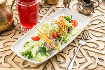 Healthy salad with lettuce, tomatoes and meat on oriental background