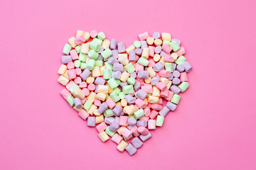Air delicious romantic heart of tender multi-colored marshmallow on a pink background