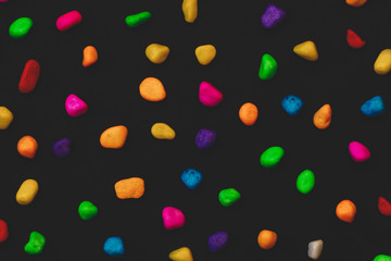small colored stones on a black background. background
