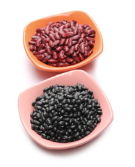 Raw red and black beans in porcelain bowl isolated on white background