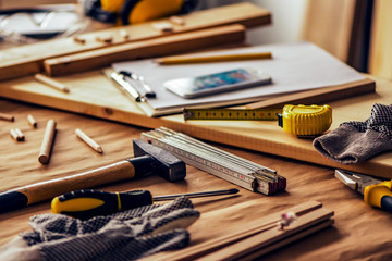 Various tools on carpentry woodwork workshop desk, selective focus