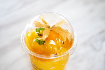 Mango smoothie drink with gooseberry and mint on top