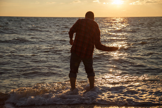 A man throws stones on the Black Sea, Sochi.