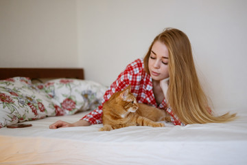 Beautiful woman hugging and playing with cat