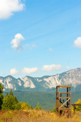 Mountain peaks in bright sunlight. Wooden construction for training on a meadow