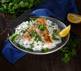 grilled fish fillet with rice on a wooden background. Rustic style.