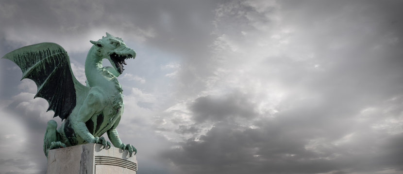 Cloudy sky over silhouette of Famous Dragon bridge, symbol of Ljubljana, capital of Slovenia, Europe. Banner optimized.