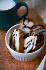 Sliced poppy seed bun in a white Cup