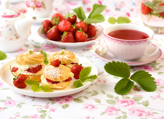 Profiterole or cream puff cakes filled with whipped cream and strawberries
