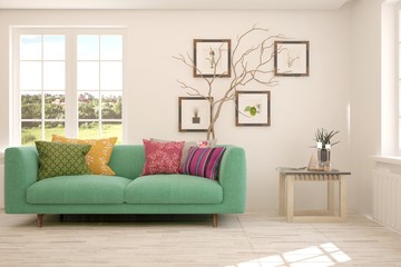 White stylish minimalist room with sofa and summer landscape in window. Scandinavian interior design. 3D illustration
