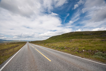 Empty road through beautiful landscape with blue sky