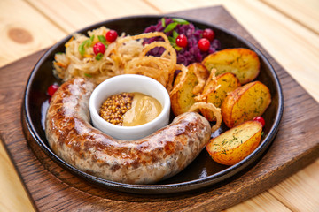 sausage with baked potatoes and salad on the wooden background