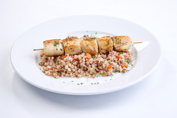 chicken kebab with buckwheat on the white plate